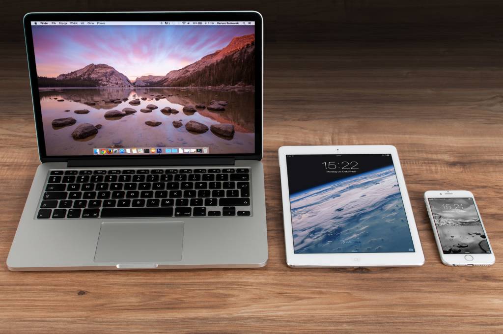 Laptop, tablet, and smartphone on a desk. Each device has a different screen size, this represents an example that website design needs to be optimized to fit the screen size.